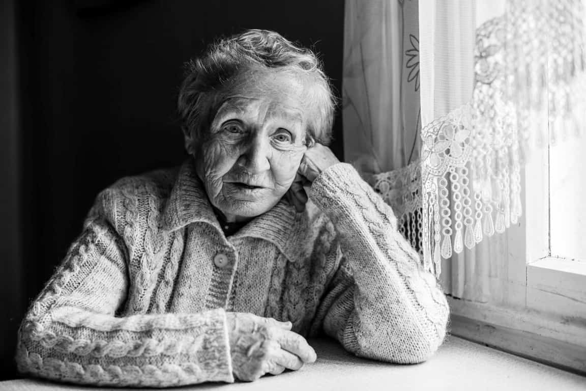 Black and white portrait of sad pensive older women.