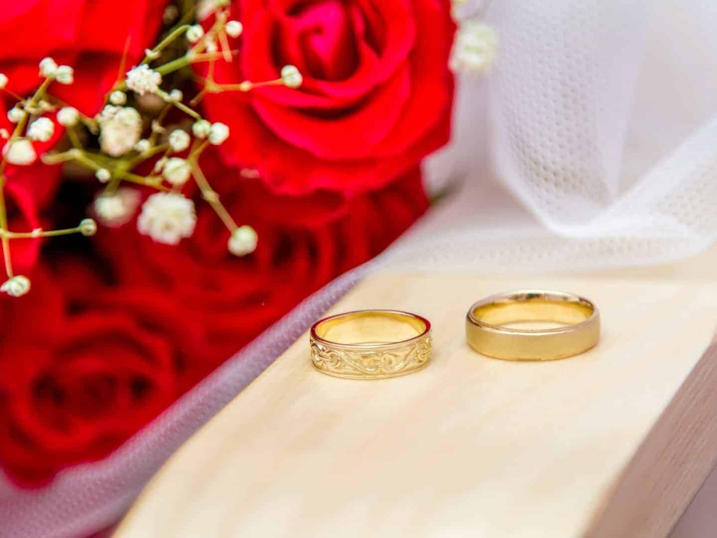 Jewish wedding - Wedding rings of bride and groom near a bouquet of red roses. Close-up